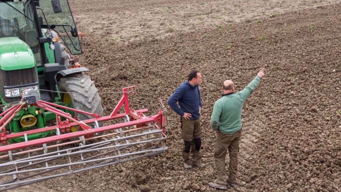 Deux agriculteurs discutant dans un champ