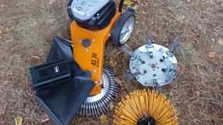 La machine, sa batterie, qui se logedans le bloc-moteur (ici, sortie à l’avant) etses deux brosses optionnelles (à droite).