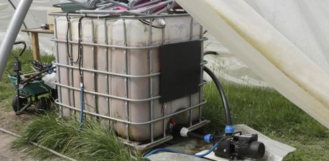 Une cuve de 1 000 l est située dans l’une des serres. Elle est remplie par une des pompes depuis la réserve de 15 m3. La petite pompe, installée à côté du récipient, assure la répartition de l’eau dans les différentes serres et parcelles. © G. Baron