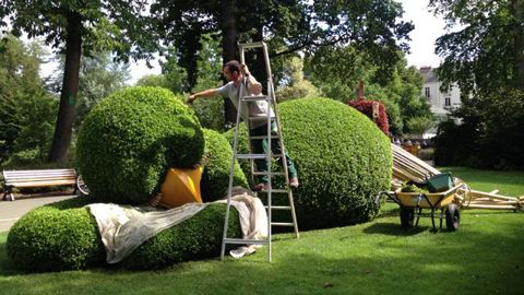 ©Odile Maillard Le poussin de Claude Ponti se fait recoiffer environ tous les 15 jours : Stéphane Coron est à l'oeuvre aux cisailles. Ce poussin, c'est le personnage le plus populaire du Jardin des plantes de Nantes. Cette année, il se repose sur la pelouse. Ayant manqué son train, sa valise fleurie attend qu'il veuille bien se décider, tandis que la voix de 