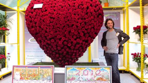 Silvano Verdesca, horticulteur à Copertino, en Italie, pose au pied du coeur immense en roses 'Red Naomi'® ; une création spectaculaire pour prouver la fraîcheur des roses produites par Porta Nova. Un coeur plus grand encore est annoncé pour la fête des Mères à Rungis.