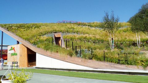 Le stand de la Belgique, avec ses pans de toits inclinés totalementvégétalisés, invite les visiteurs à la promenade.