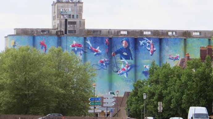  L'artiste Florent Maussion a réalisé cette fresque représentant un enfant en train de peindre, et en quelque sorte, de donner vie à des carpes koï.  L'artiste Florent Maussion a réalisé cette fresque représentant un enfant en train de peindre, et en quelque sorte, de donner vie à des carpes koï.