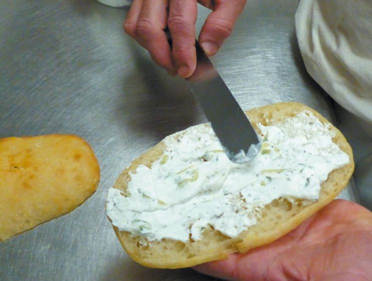       Trancher le pain ciabatta et tartiner la base 
      de tzatziki. 
