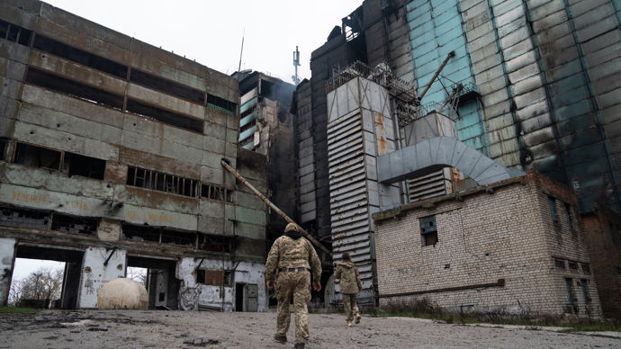 Soldats ukrainiens marchant aux abords d'un silo en feu à Snihourivka (district de Kerson), le 16 novembre 2022.