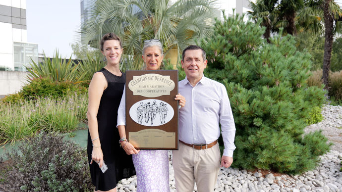 Au centre, Marilyne Rousset, entourée d'Anaïs Labielle et Ignacio Eceiza, tous trois dans la commission inscription d'Euralis, avec le bouclier des coopératives remporté lors du dernier semi-marathon chez Axéréal.