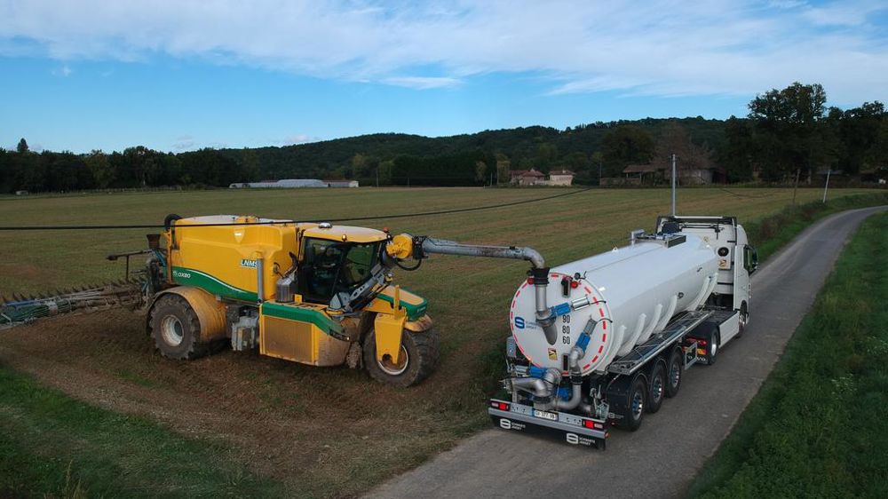 Arrivé au champ, le poids lourd stationne en bord de route, et l’épandeur se rapproche pour le ravitaillement.