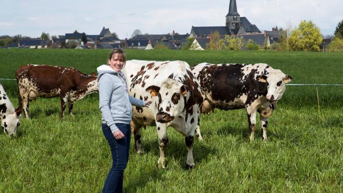 Jeune agricultrice avec vaches.