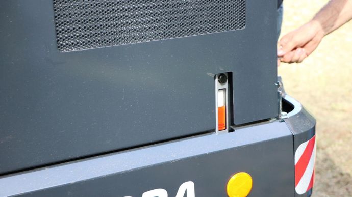 Le chauffeur vérifie le niveau d'huile en un coup d'oeil sur le côté de la machine grâce à l'indicateur de niveau.