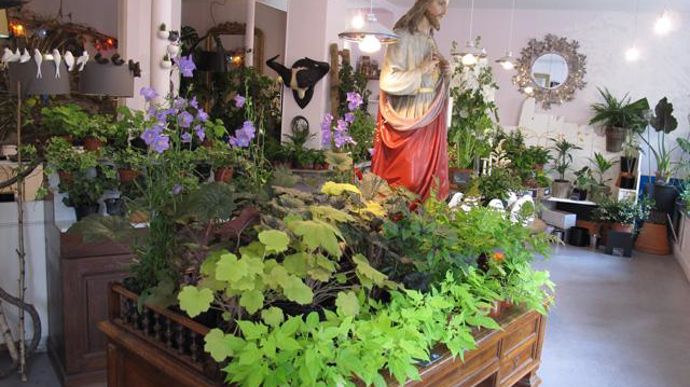 ©Odile Maillard Les Mauvaises Graines, point de vente atypique, où la décoration est à l'origine de l'ambiance « rock » du lieu. Ici, une statue du Christ côtoie plantes et meubles chinés. 